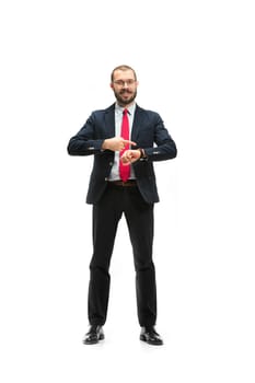 Businessman looking at his watch on his hand, watching the time. portrait of businessman on white studio background. Serious bearded young man in glasses, suit, red tie standing in office. Business concept.