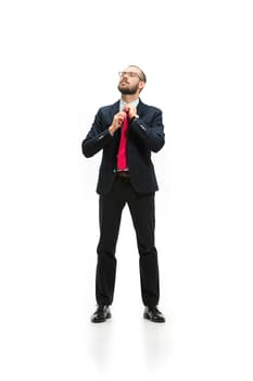 Full body or full-length portrait of businessman on white studio background. Serious bearded young man in glasses, suit, red tie standing in office. Business, career, success concept.
