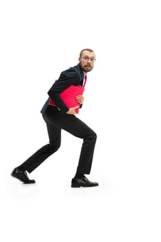 Full body or full-length portrait of businessman stealing with red folder on white studio background. frightened bearded young man in glasses, suit stealing in office. Business, career, fear concept. Profile