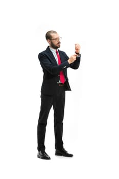 Full body or full-length portrait of businessman on white studio background. Serious bearded young man in glasses, suit, red tie standing in office. Business, career, success concept.