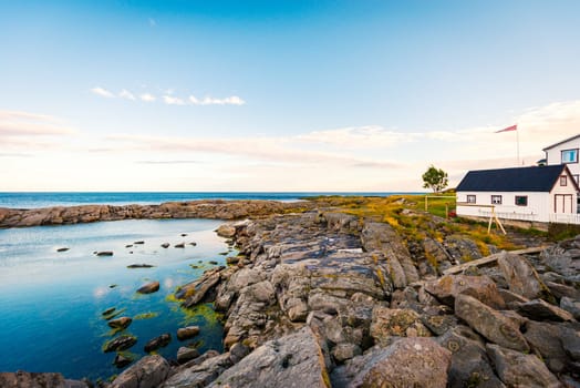 Village of Reine on Lofoten islands in Norway. Traditional wooden house. Sunset sky with clouds. Travel in Scandinavia, Europe.