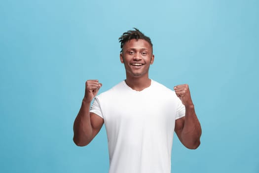 I won. Winning success happy afro man celebrating being a winner. Dynamic image of afro-american male model on blue studio background. Victory, delight concept. Human facial emotions concept. Trendy colors