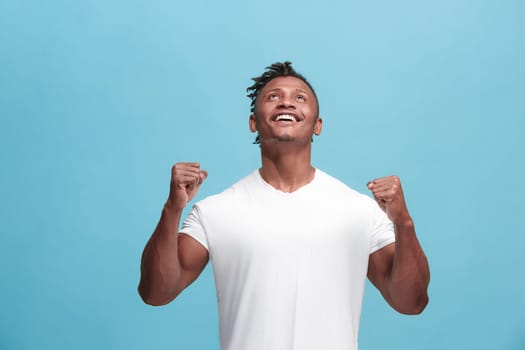 I won. Winning success happy afro man celebrating being a winner. Dynamic image of afro-american male model on blue studio background. Victory, delight concept. Human facial emotions concept. Trendy colors