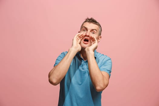 Do not miss. Young casual man shouting. Shout. Crying emotional man screaming on pink studio background. male half-length portrait. Human emotions, facial expression concept. Trendy colors