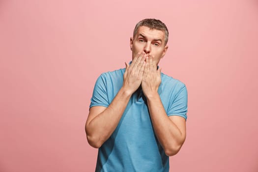 I kiss you. Portrait of attractive man with kiss on lips. Pink studio. Beautiful male portrait. Young happy emotional funny man looking at camera. Human facial emotions concept. Trendy colors