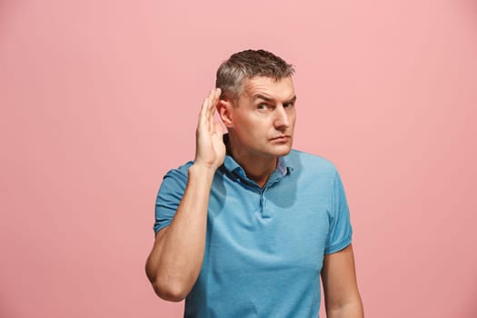 The happy business man standing and young man listening isolated on trendy pink studio background. Beautiful male half-length portrait. Young satisfy man. Human emotions, facial expression concept.