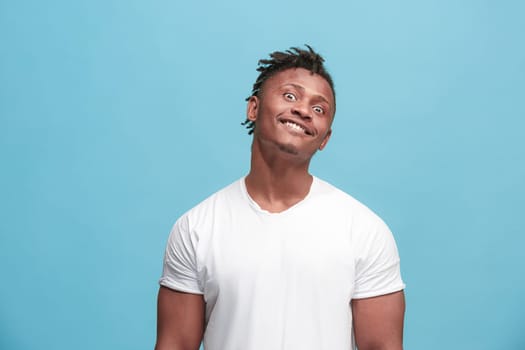 I lost my mind. The squint eyed man with weird expression. Beautiful male half-length portrait isolated on blue studio backgroud. The crazy man. The human emotions, facial expression concept.