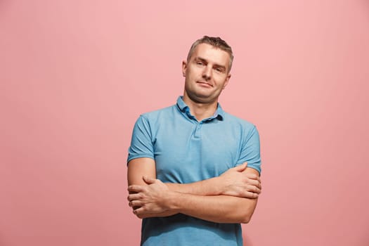 Happy business man standing and smiling isolated on pink studio background. Beautiful male half-length portrait. Young emotional man. The human emotions, facial expression concept. Front view.