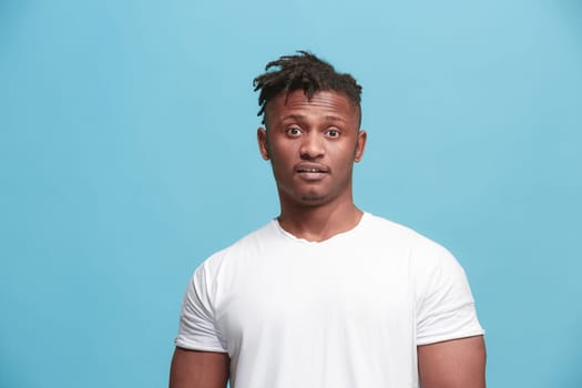 Surprised business Afro-American man standing and looking isolated on pink studio background. African American male portrait. Young emotional man. The human emotions, facial expression concept.
