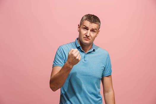 Argue, arguing concept. Beautiful male half-length portrait isolated on pink studio backgroud. Young emotional surprised man looking at camera. Human emotions, facial expression concept. Front view
