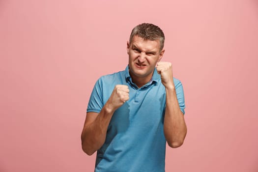 Screaming, hate, rage. Crying emotional angry man screaming on pink studio background. Emotional, young face. male half-length portrait. Human emotions, facial expression concept. Trendy colors