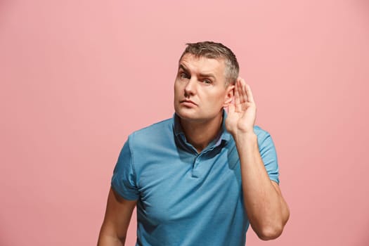 The happy business man standing and young man listening isolated on trendy pink studio background. Beautiful male half-length portrait. Young satisfy man. Human emotions, facial expression concept.