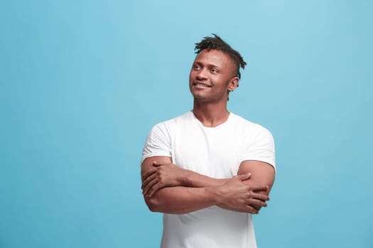 Happy business afro man standing and smiling isolated on blue studio background. Afro-american male half-length portrait. Young emotional man. The human emotions, facial expression concept. Front view.