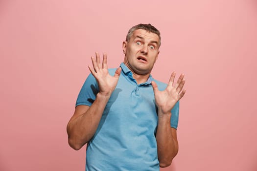I'm afraid. Fright. Portrait of the scared man. Business man standing isolated on trendy pink studio background. male half-length portrait. Human emotions, facial expression concept. Front view