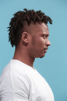 Surprised business Afro-American man standing and looking isolated on blue studio background. African American male profile portrait. Young emotional man. The human emotions, facial expression concept.