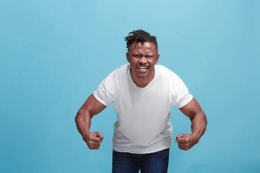 Screaming, hate, rage. Crying emotional angry afro man screaming on blue studio background. Emotional, young face. male half-length portrait. Human emotions, facial expression concept. Trendy colors