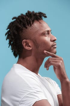 Reject, rejection, doubt concept. Doubtful man with thoughtful expression making choice. Young emotional man. Human emotions, facial expression concept. Profile. Studio. Isolated on trendy blue