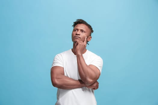 Remember all. Let me think. Doubt concept. Doubtful, thoughtful Afro-Fmerican man remembering something. Young emotional man. Human emotions, facial expression concept. Studio. Isolated on trendy blue