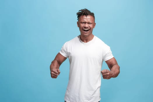 Screaming, hate, rage. Crying emotional angry afro man screaming on blue studio background. Emotional, young face. male half-length portrait. Human emotions, facial expression concept. Trendy colors