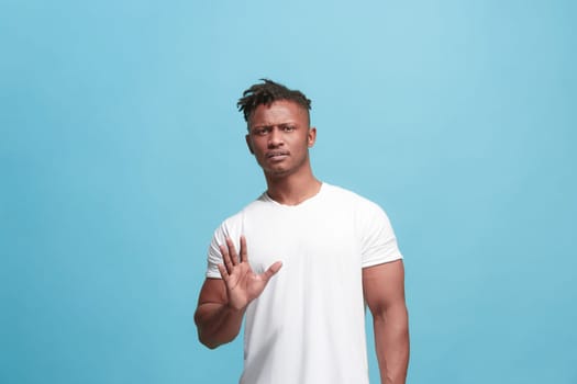 Ew. It's so gross. Young afro man with disgusted expression repulsing something. Disgust concept. Young emotional man. Human emotions, facial expression concept. Studio. Isolated on trendy blue color
