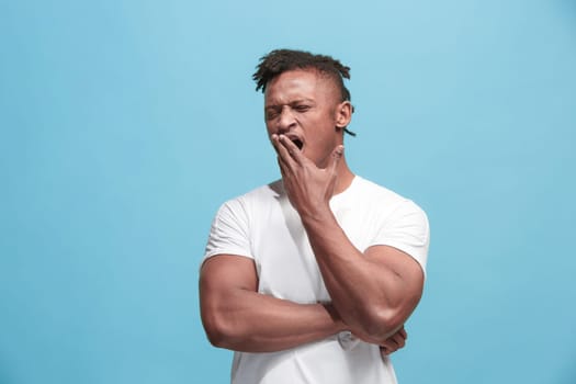 I am tired of everything. Bored man. Boring, dull, tedious concept. Young caucasian emotional man. Human emotions, facial expression concept. Studio Isolated on trendy blue background