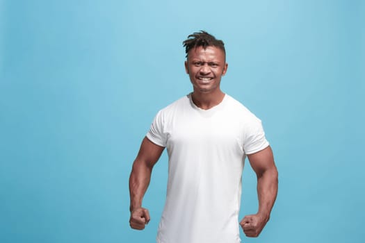 Screaming, hate, rage. Crying emotional angry afro man screaming on blue studio background. Emotional, young face. male half-length portrait. Human emotions, facial expression concept. Trendy colors