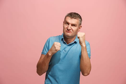 Screaming, hate, rage. Crying emotional angry man screaming on pink studio background. Emotional, young face. male half-length portrait. Human emotions, facial expression concept. Trendy colors