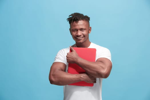 Businessman hugging laptop. Love to computer concept. Attractive afro male half-length front portrait, trendy blue studio backgroud. Young emotional man. Human emotions, facial expression concept.