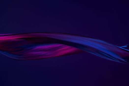 Smooth elegant transparent blue cloth isolated or separated on dark blue studio background. Texture of flying silk fabric.