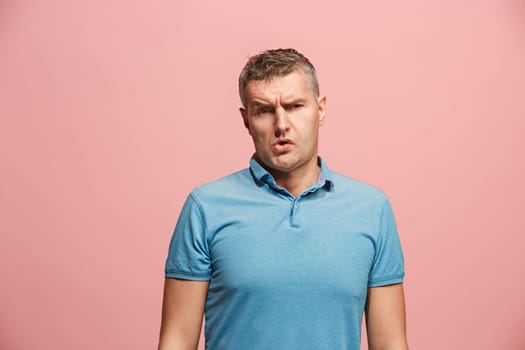 I am tired of everything. Bored man. Boring, dull, tedious concept. Young caucasian emotional man. Human emotions, facial expression concept. Studio Isolated on trendy pink background