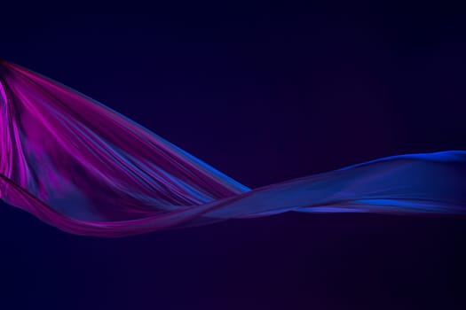 Smooth elegant transparent blue cloth isolated or separated on dark blue studio background. Texture of flying silk fabric.