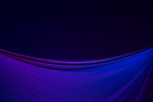 Smooth elegant transparent blue cloth isolated or separated on dark blue studio background. Texture of flying silk fabric.