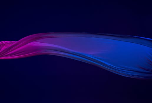 Smooth elegant transparent blue cloth isolated or separated on dark blue studio background. Texture of flying silk fabric.