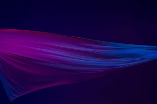 Smooth elegant transparent blue cloth isolated or separated on dark blue studio background. Texture of flying silk fabric.