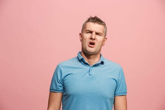 I am tired of everything. Bored man. Boring, dull, tedious concept. Young caucasian emotional man. Human emotions, facial expression concept. Studio Isolated on trendy pink background