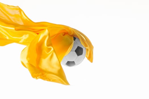 Soccer ball and Smooth elegant transparent yellow cloth isolated or separated on white studio background. Texture of flying fabric. yellow. Attributes of popular game. Concept of national flag color