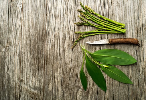 Spring food wild garlic and asparagus on wooden background