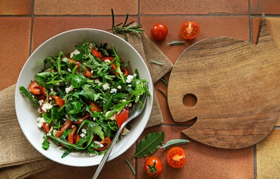 Rocket Salad with arugola tomato and cheese on background.