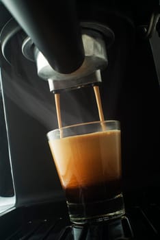 Espresso pouring from coffee machine. Professional coffee brewing
