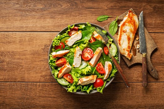 Fresh salad with chicken breast and tomato. Top view