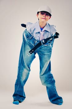 Caucasian boy wearing his Dad's shirt, jeans and tie on light background. He is wearing big adult size clothes which are too big for him.