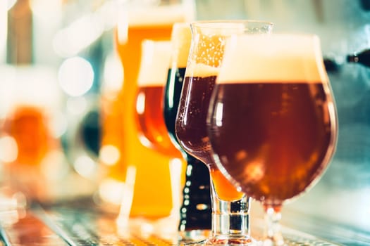 The beer taps in a pub. nobody. Selective focus. Alcohol concept. Vintage style. Beer craft. Bar table. Steel taps. Shiny taps. Glass of beer