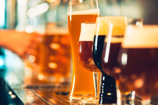 The beer taps in a pub. nobody. Selective focus. Alcohol concept. Vintage style. Beer craft. Bar table. Steel taps. Shiny taps. Glass of beer. Octoberfest concept