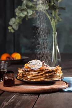 Fresh homemade french crepes made with ffresh fruits on a vintage wooden board on the wooden table. Side view with honey, fruits and coffee. French pancakes concept