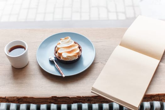 Cup of coffee, cake, wooden windowsill. In the background white window. Barista, cafe, making coffee, preparation and service concept.