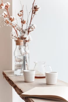 Cup of coffee, branch of tree, wooden windowsill. In the background white window.