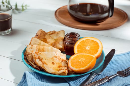 Fresh homemade french crepes made with ffresh fruits on a vintage wooden board on the wooden table. Side view with honey, fruits and coffee. French pancakes concept