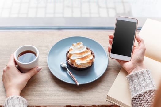 Cup of coffee, cake, wooden windowsill. In the background white window. Barista, cafe, making coffee, preparation and service concept.
