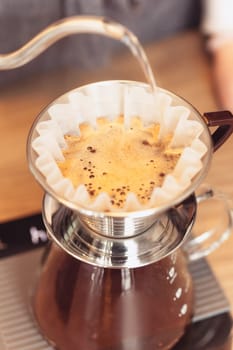 Hand drip coffee, Barista pouring water on coffee ground with filter. Barista, cafe, making coffee, preparation and service concept. Hipster syile