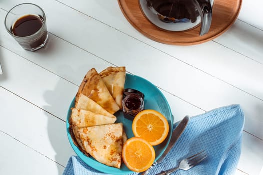 Fresh homemade french crepes made with ffresh fruits on a vintage wooden board on the wooden table. Top view with honey, fruits and coffee. French pancakes concept